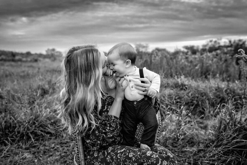 Family photography session of family cuddling in grassy field in Bloomington/Normal, Illinois