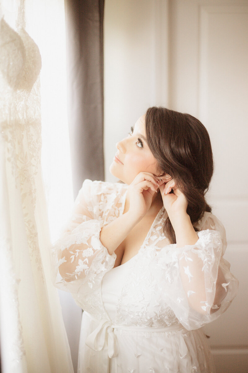 This image is a bride putting on her earrings.
