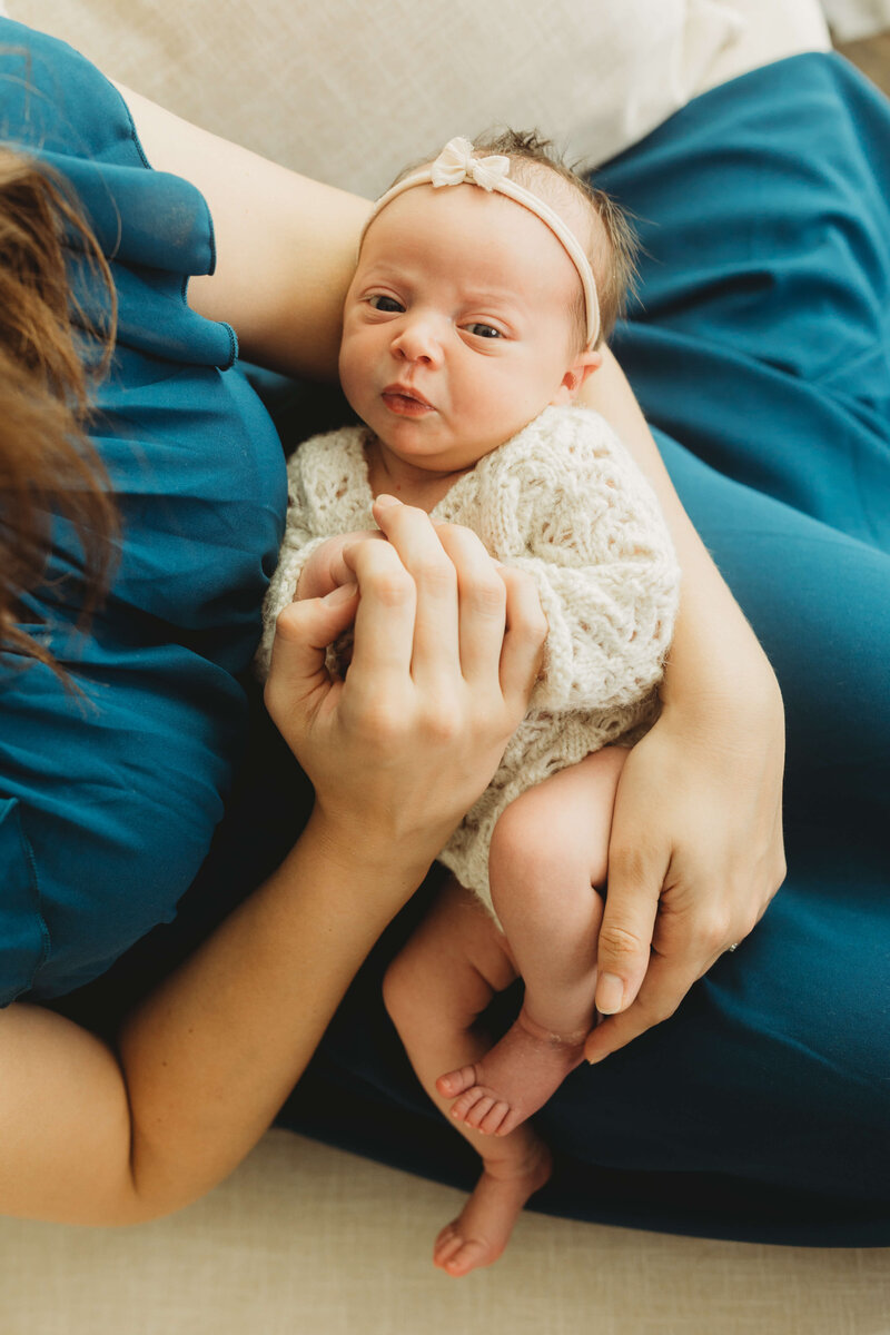 dad with blue eyes in an olive green henley holding his swaddled baby boy in harrisburg newborn photos