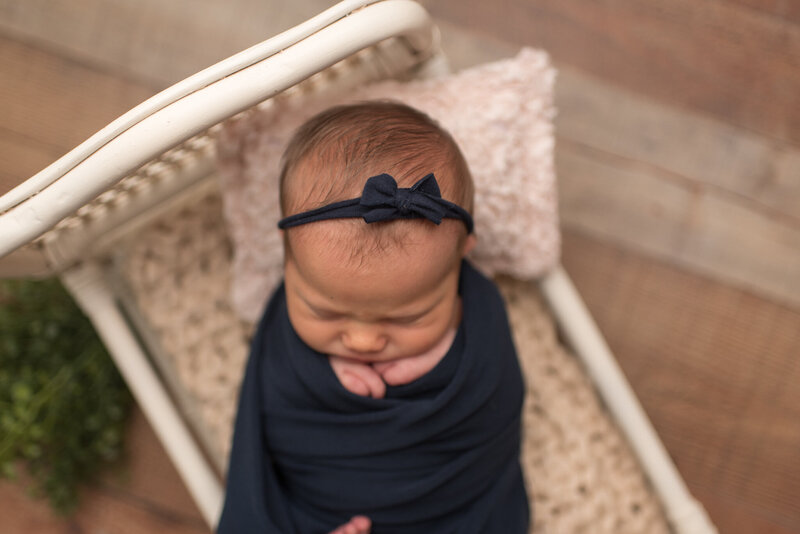 Close up of baby girl wrapped in navy blue at her newborn session