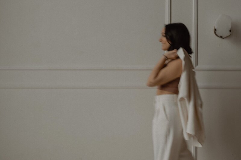 Soft focus shot of Vickie of VERVE & COLOR holding her white coat over her shoulder.
