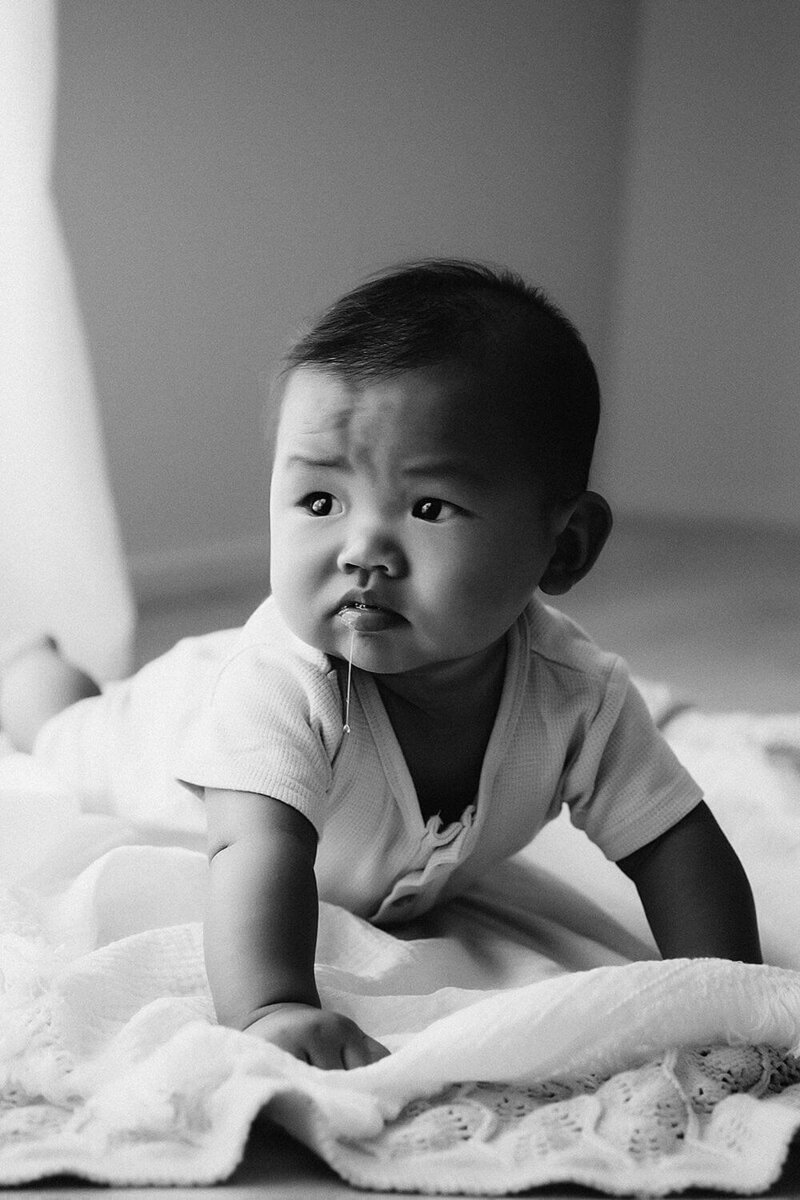 A little baby boy dribbles during his baby photoshoot with new plymouth photographer aimee kelly photography