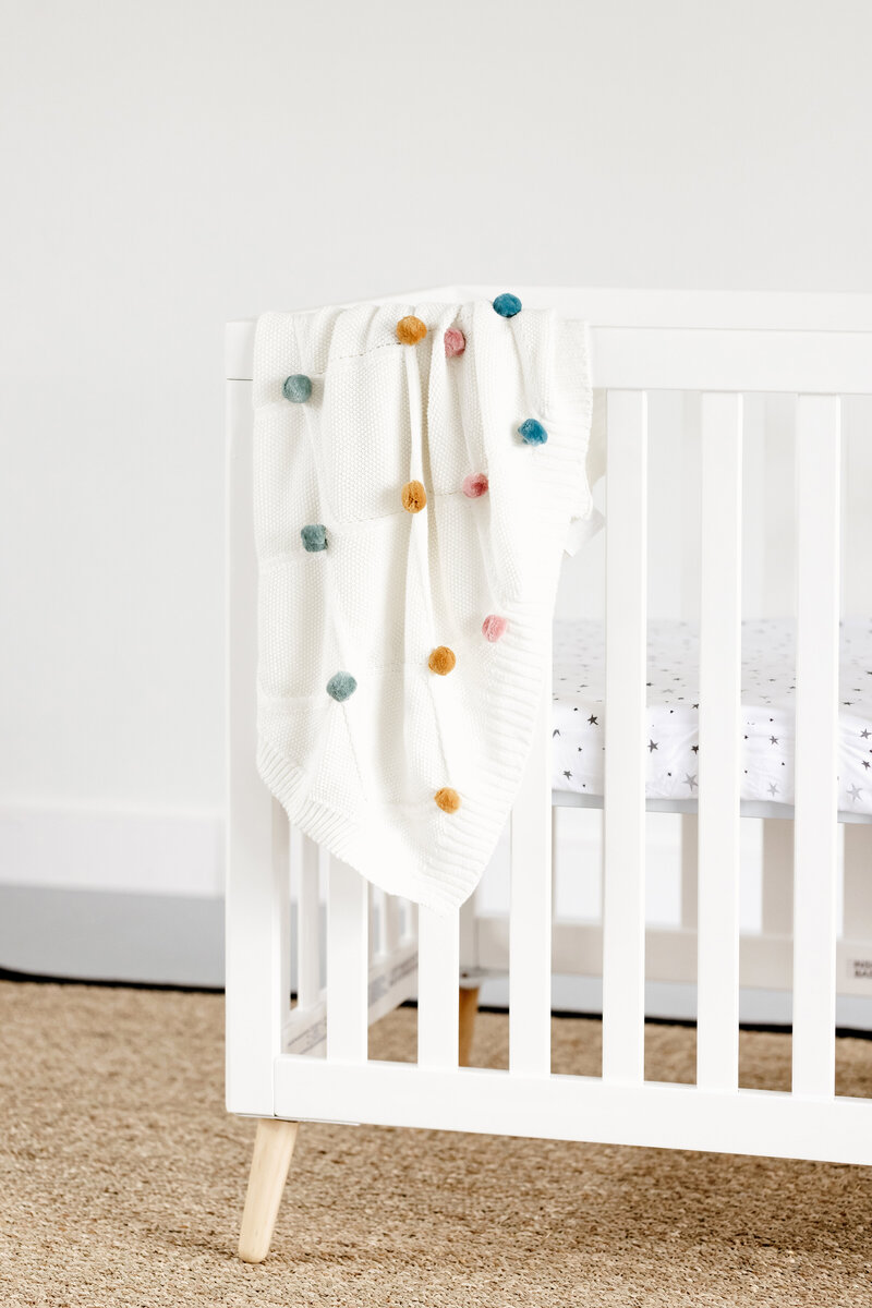 White crib with blanket