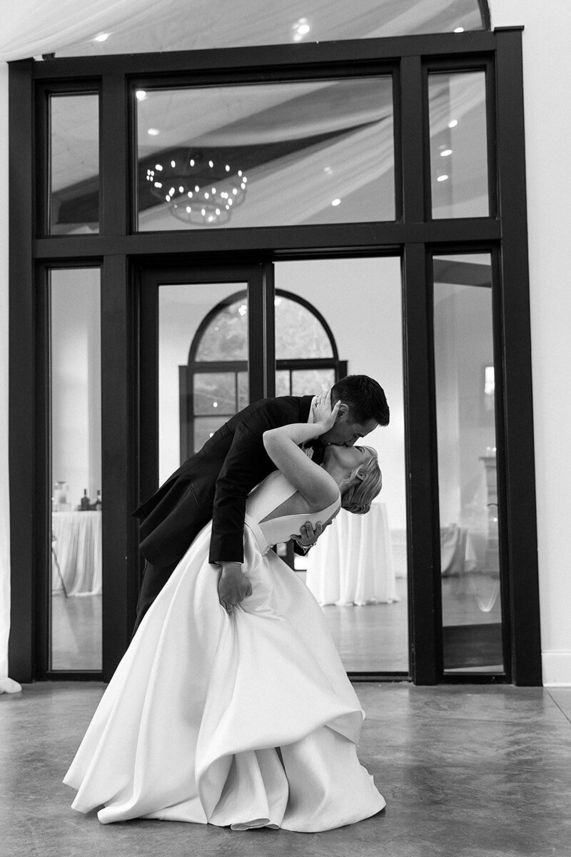 Bride and groom's deep kiss in front of a glass door