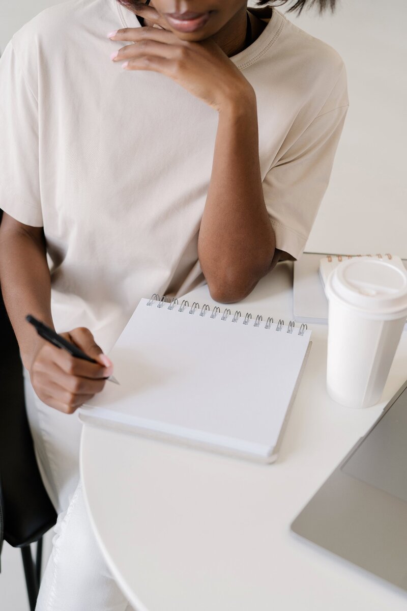 Close up shot of a woman writing on her notebook