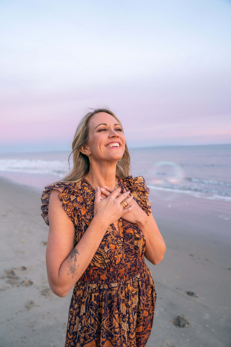 A woman life coach on the beach in Malibu California with her arms on top of eachother on her chest