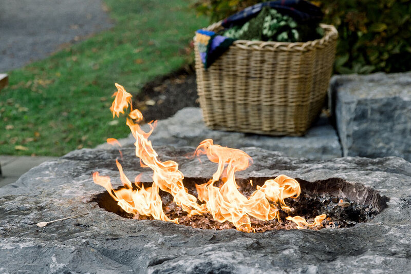 closeup of outdoor firepit that is lit with stone surround