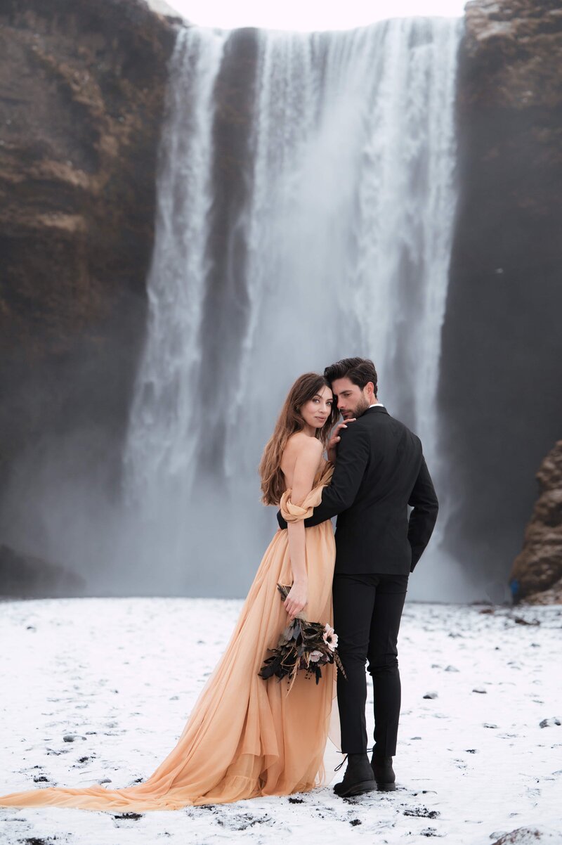 Couple in Iceland saying vows under skogafoss