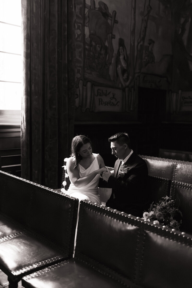 Elopement couple sitting quietly in courthouse pews at Santa Barbara courthouse wedding