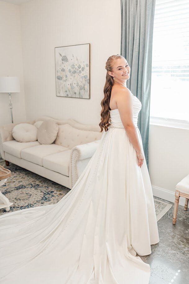 Bride in white wedding dress on sofa