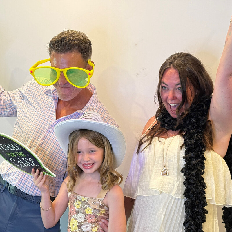 Three guests posing with props and big smiles