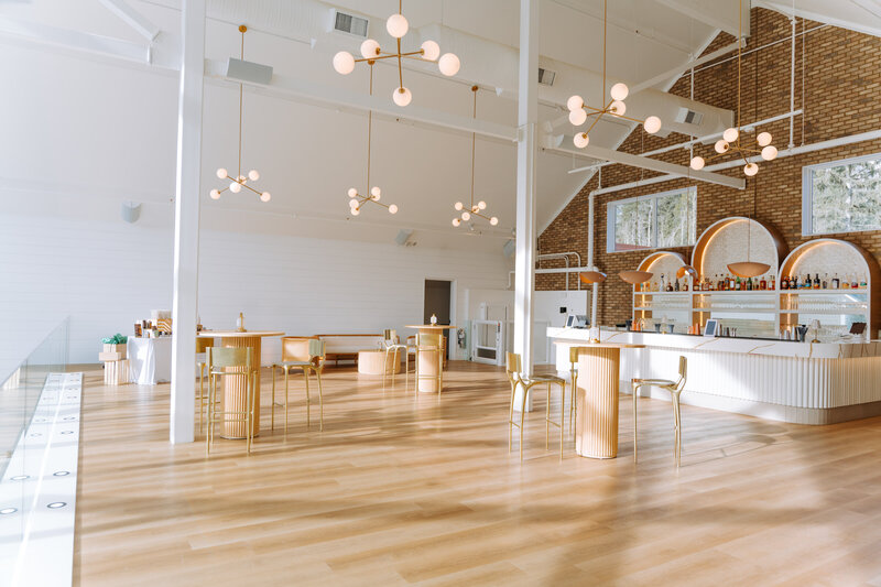 Luxury rooftop patio at Sevenfold in Canmore with a cozy fire-pit, plush white seating, and panoramic mountain views at sunset.