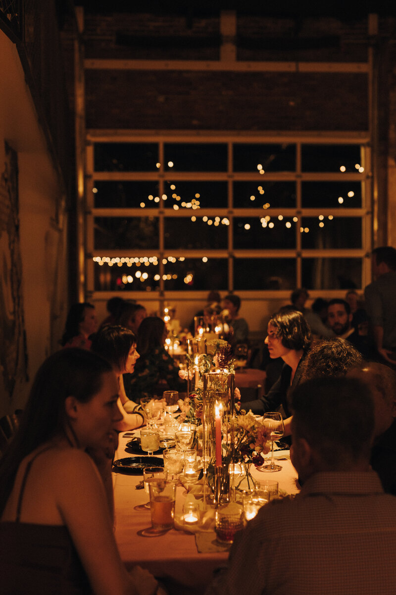 Guests eating dinner under warm ambient light