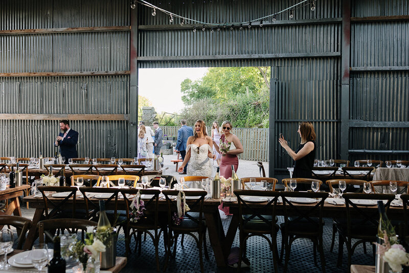 Bride looking at wedding decor in a rustic industrial barn wedding