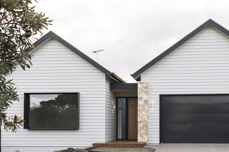 White custom home build in Geelong with weatherboard panels and a wooden door in Geelong.