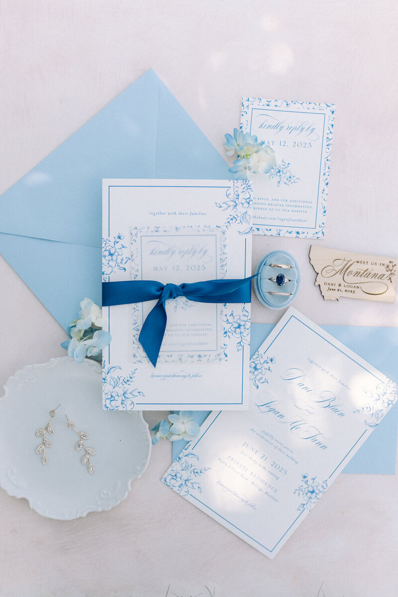 Elegant blue and white luxury wedding invitation suite with floral details and satin ribbon by Seventh and Anderson, perfect for Montana weddings