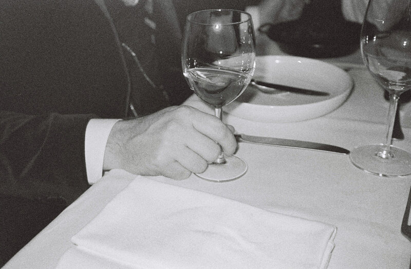 Black and white photos of a person's hand holding a wine glass