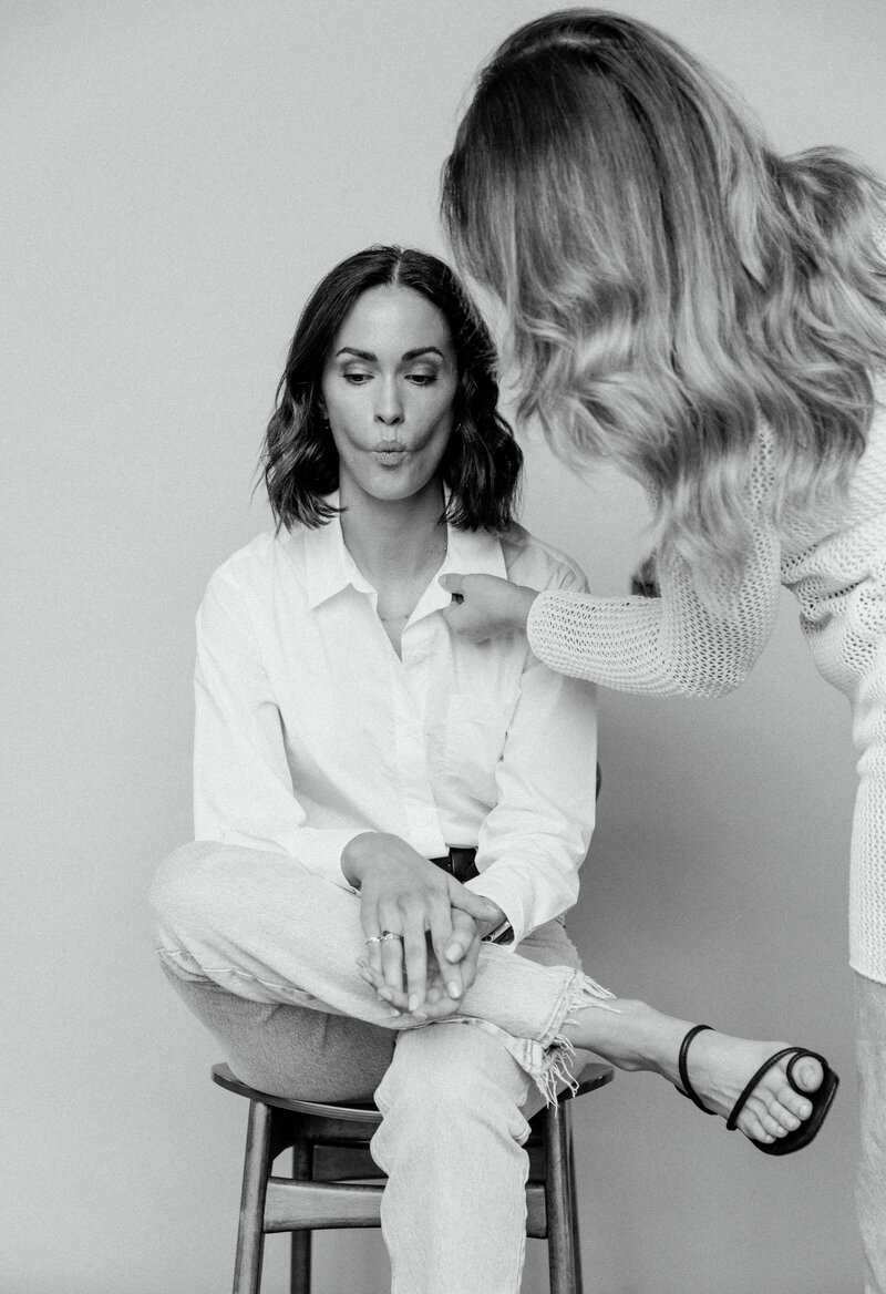 Girl posing for a photoshoot while someone fixes their hair