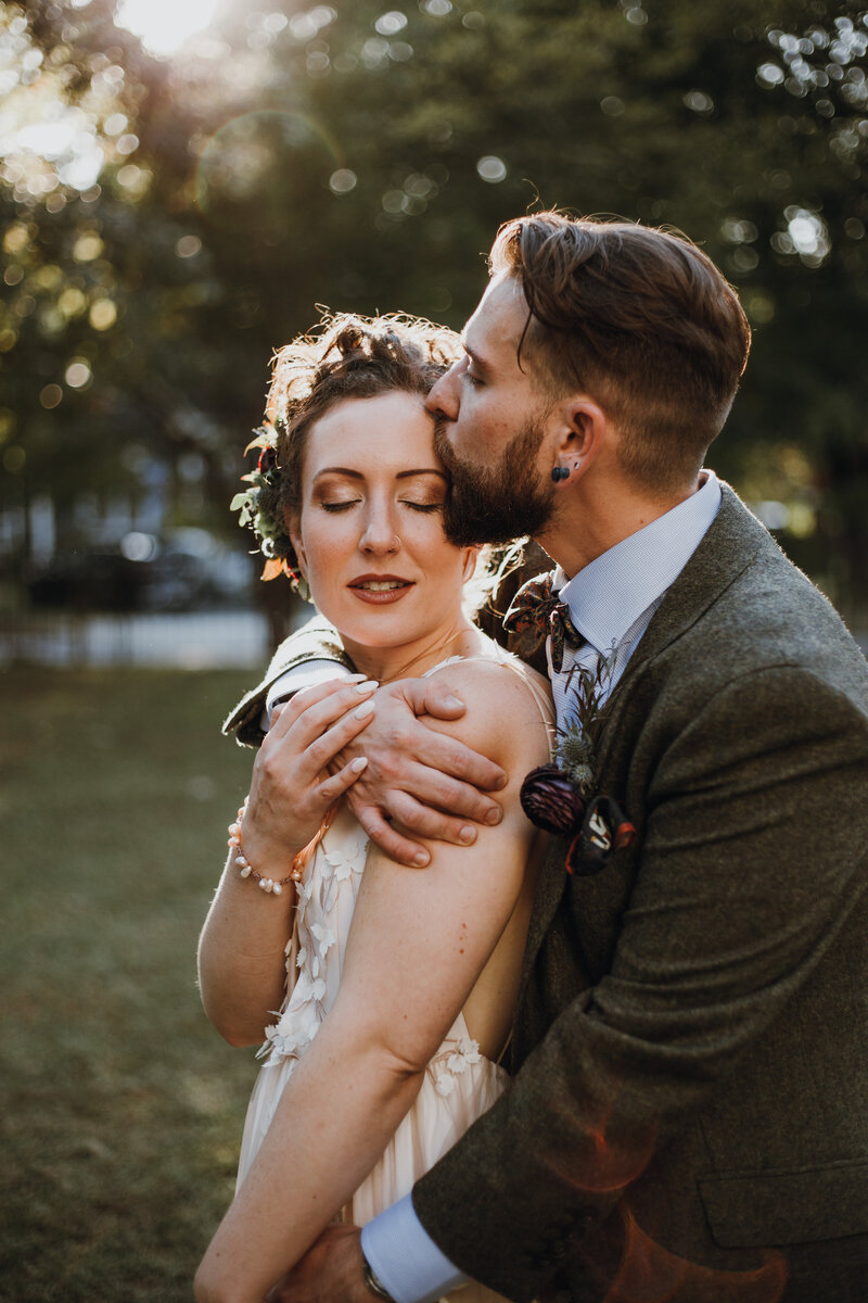 groom kissing bride on the forehead