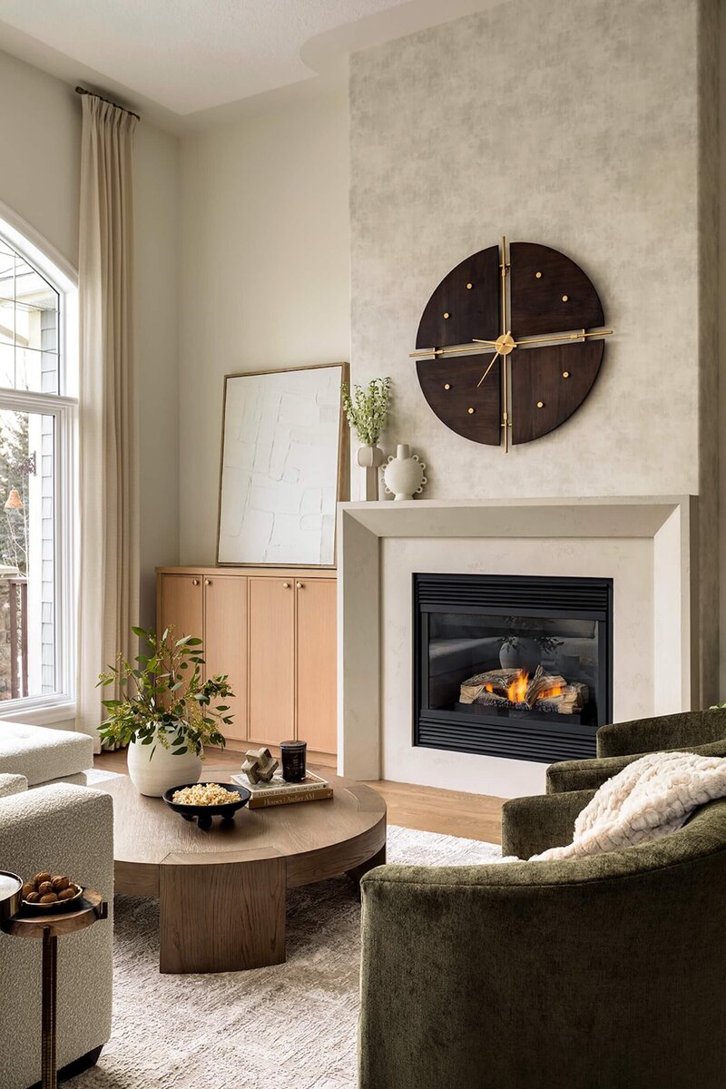 Stone fireplace with wallpaper and white oak cabinets. 