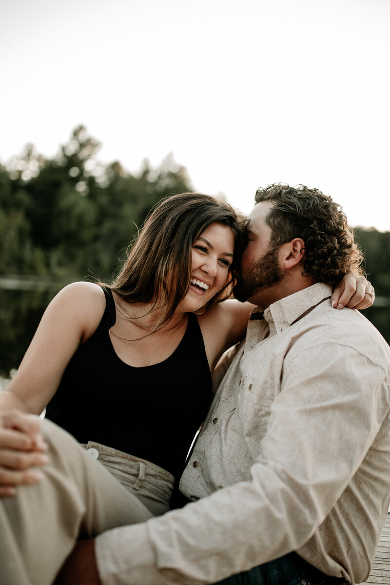Maddie and Dawson cozy up on a boat during their lake engagement session.