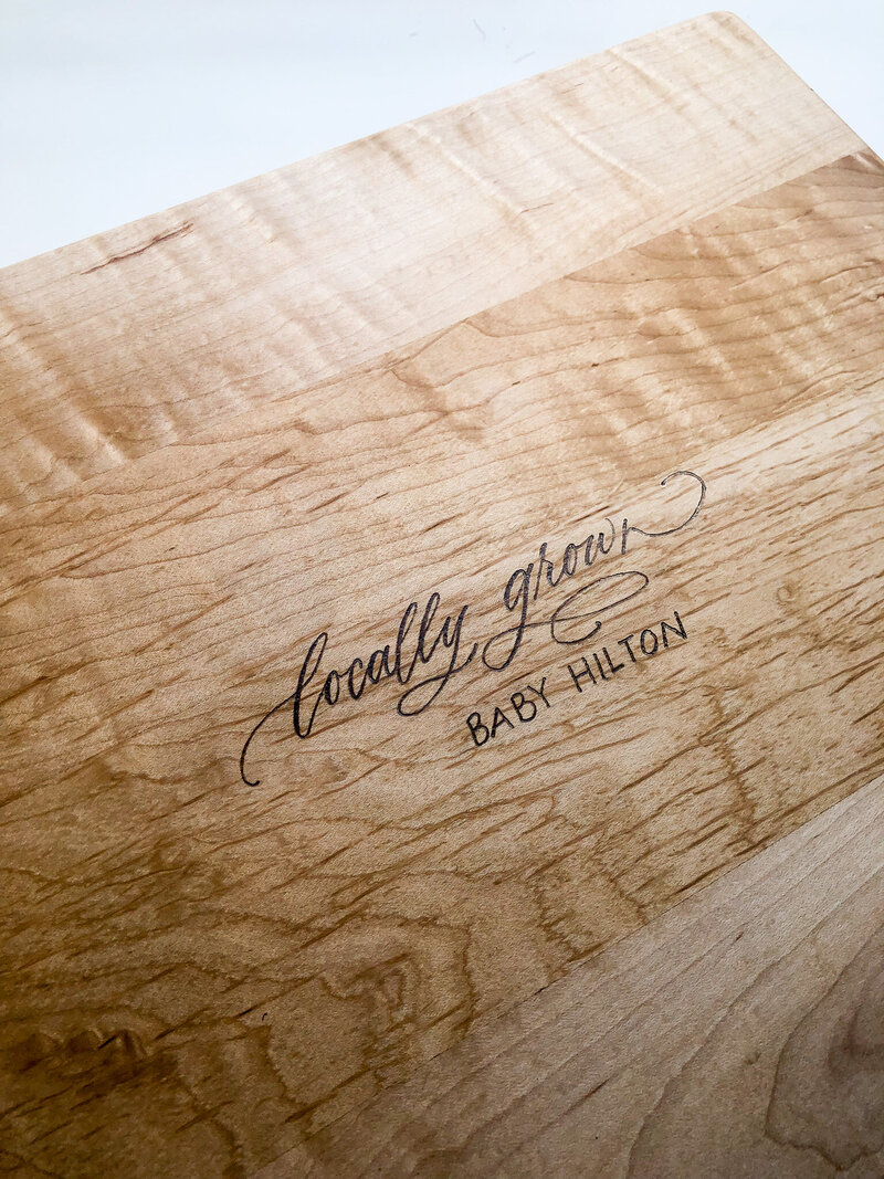 a wood cutting board with wood burned calligraphy personalization