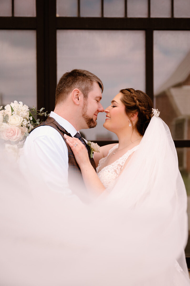 bride and groom wrapped in veil