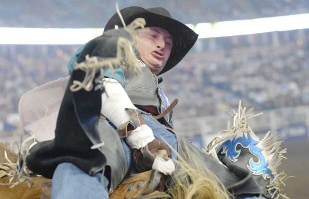 A rodeo athlete wearing an elbow brace while competing at an event.