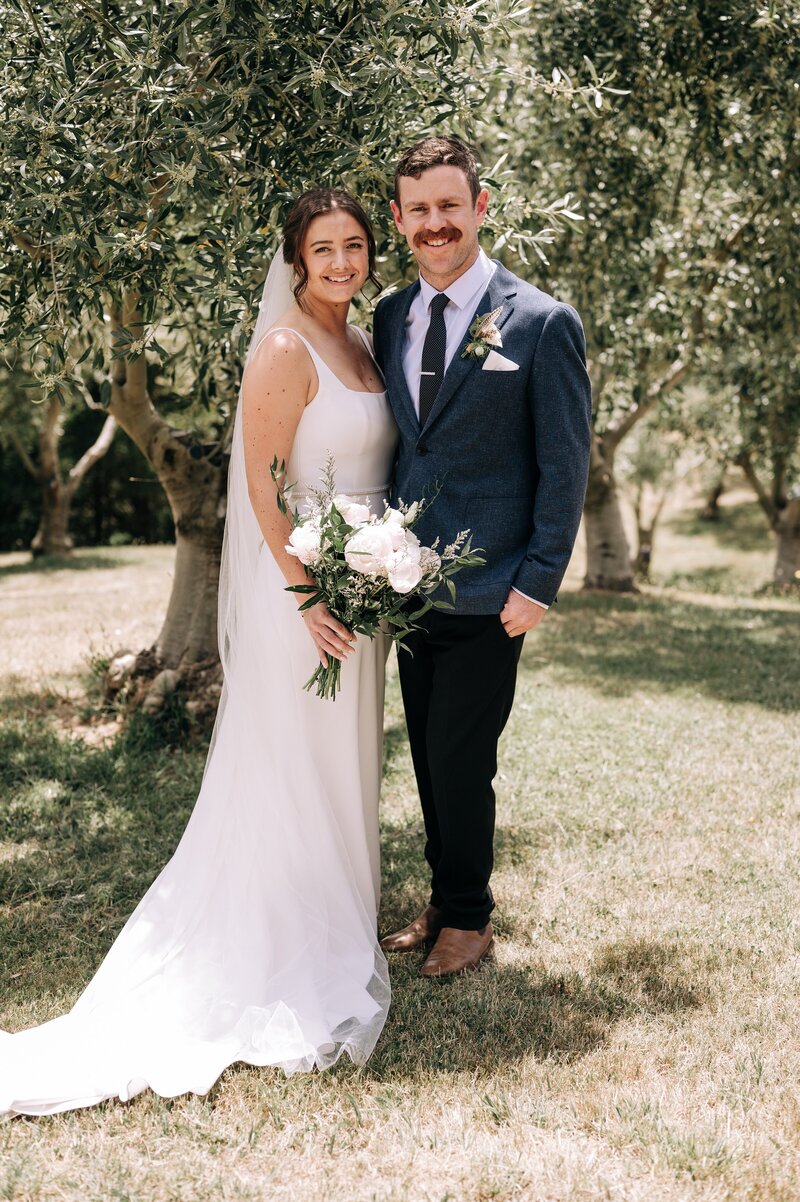 bride and groom in olive grove in akaroa at their mt vernon lodge wedding venue