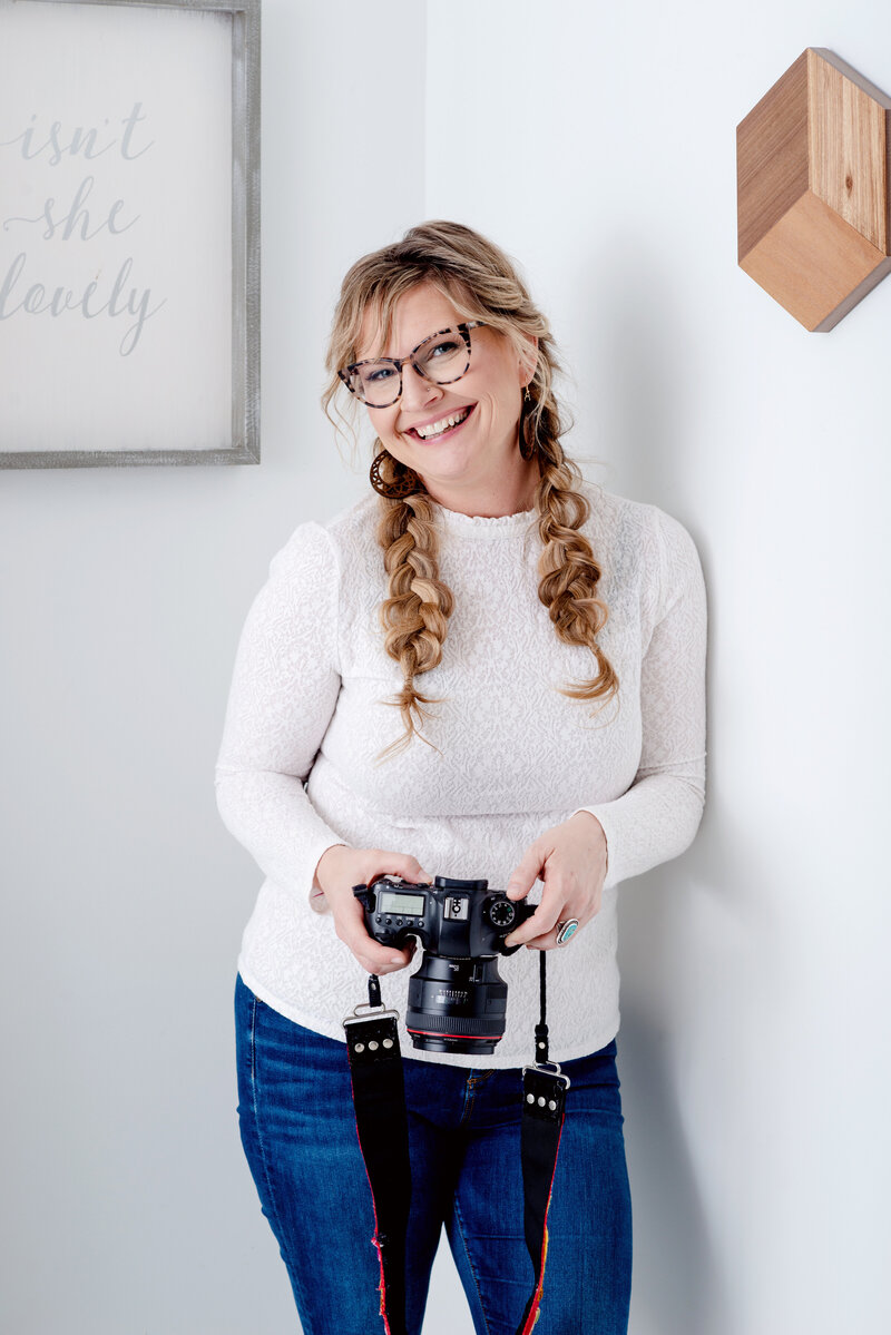 Kat Jones bio portrait with her camera.