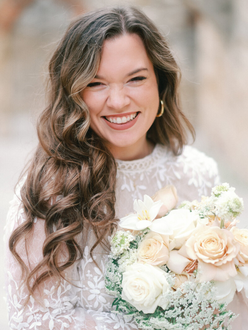 Fun film photographer smiling and laughing at camera with floral bouquet