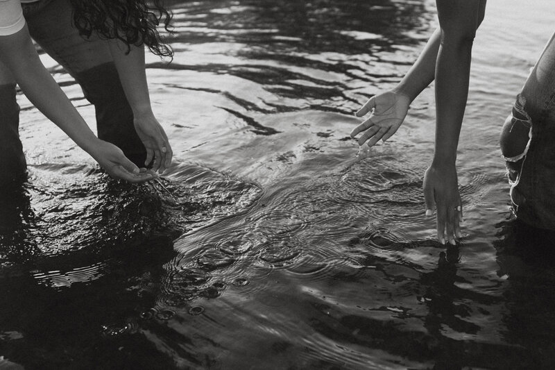 A couple splashing water at each other in a lake 