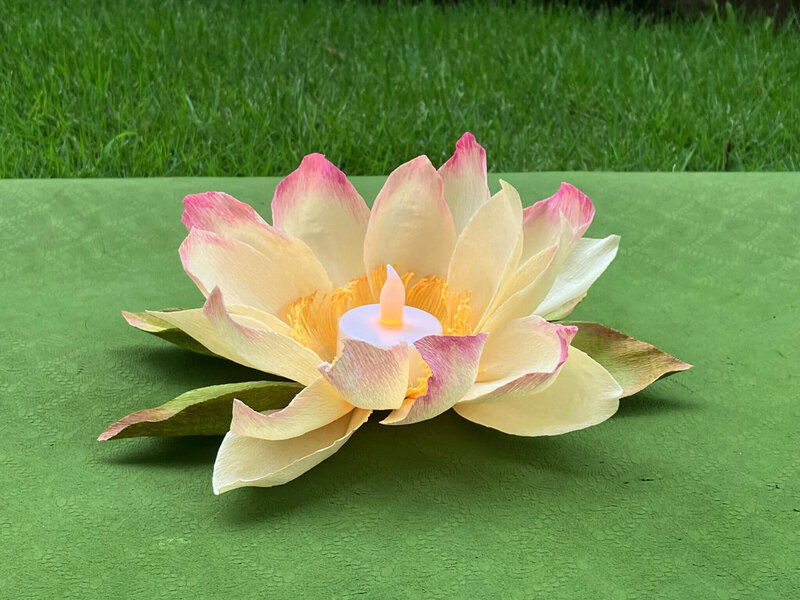 Paper lotus tealight on a green yoga mat