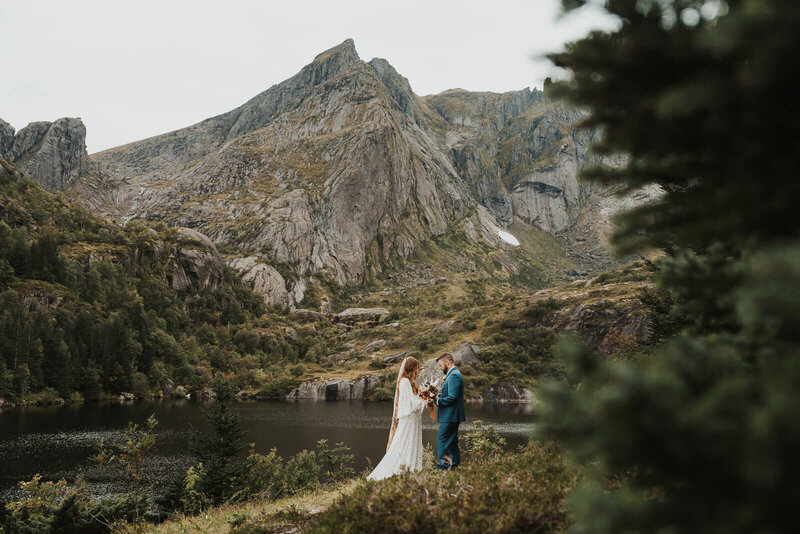 Elopement couple  saying their vows by a mountain lake in Lofoten