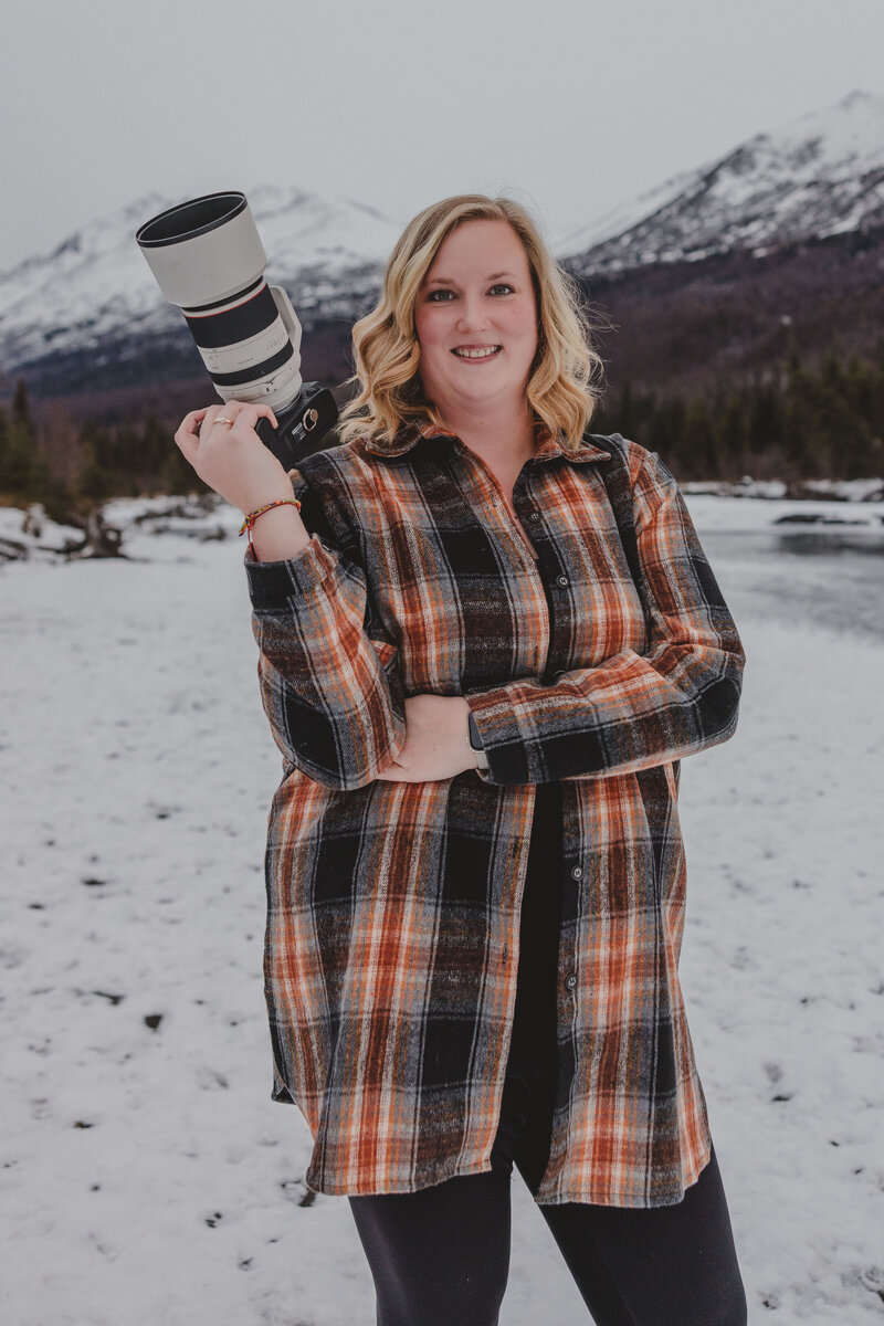 Alaska Elopement Photographer, Kyla Steward, posed holding a camera.