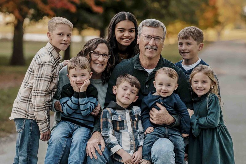 Family gathers with grandparents and grandchildren to take a photo.