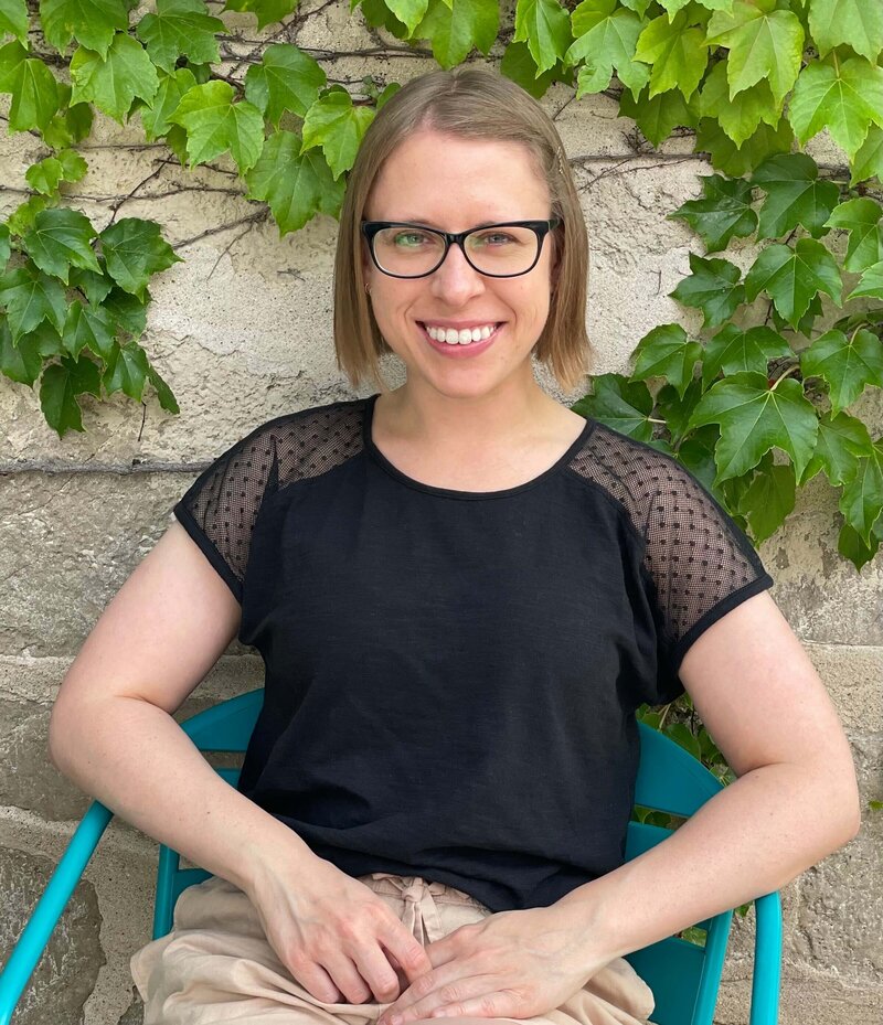 Stephanie stands in front of an ivy-covered stone building in Cedarburg, Wisconsin.