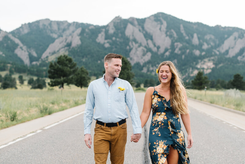 Couple walking down a road in front of mountains holding hands - Northern Virginia family photographer