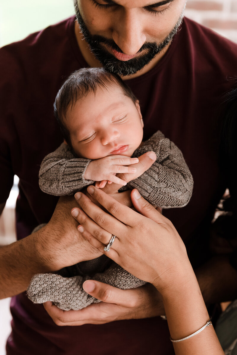 Indian newborn baby boy close up against father's chest with natural studio lighting - multicultural family photography by Glean and Co Boise studio