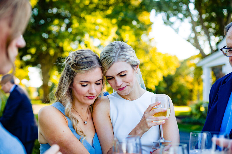 A bride and her sister  embracing during dinner at Cornman Farms in Dexter Michigan