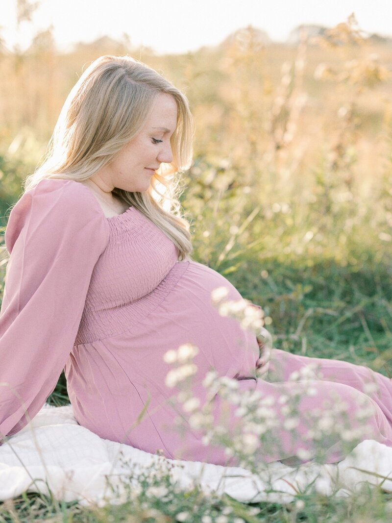 pregnant-mom-sitting-in-field-on-blanket
