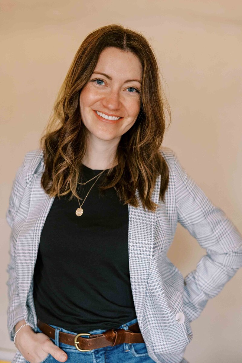 photographer with one hand in her pocket and smiling at the camera