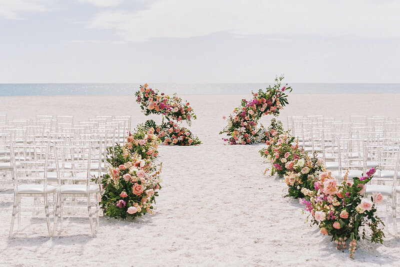 Romantic beach wedding ceremony setup with pastel floral arrangements and ocean views at Ritz Carlton Sarasota Beach Club — fine-art destination wedding captured by Asia Pimentel Photography.