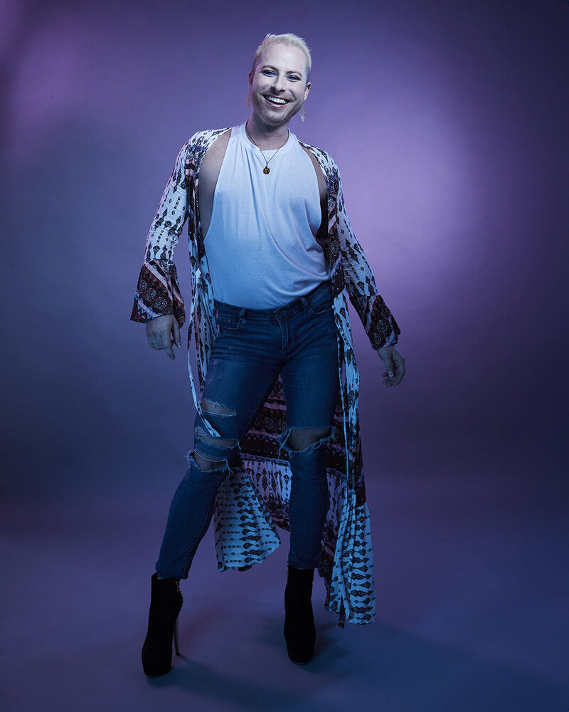 Elegant studio shot of Dain August in a blue sequined ensemble, standing with a poised expression, captured by Ylva Erevall.
