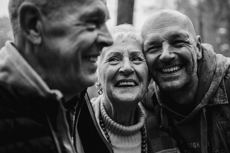 Zwart-wit portret van drie generaties die samen lachen, vastgelegd door Beau à Bo - familieportret met focus op verbondenheid en vreugde