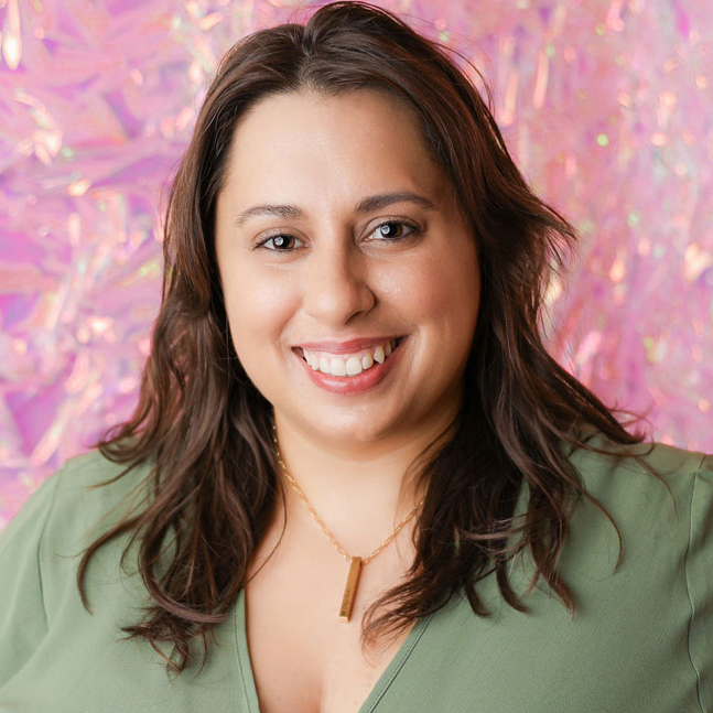 Brand transformation strategist and podcast host, Lena Gosik-Wolfe wearing green in front of an iridescent pink background.
