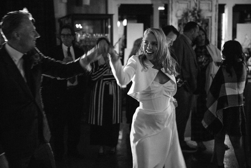 black and white photo of a bride dansing in a corset white dress