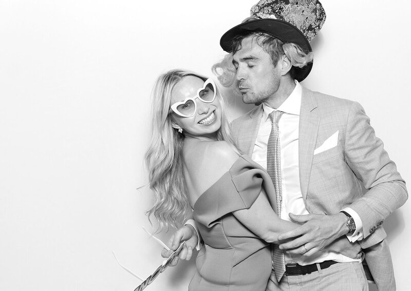 couple posing against a white backdrop with a Kardashian filter, during a corporate event, for Mad Hat Photo Booth Farleigh House party entertainment