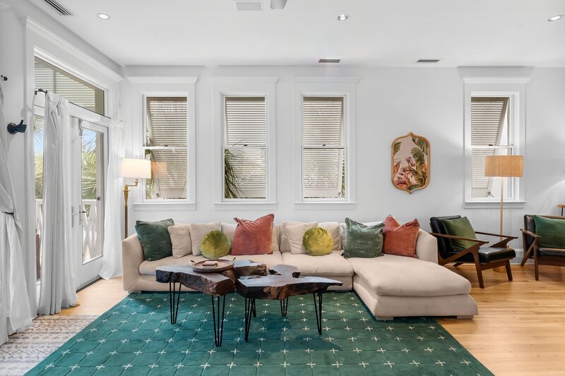 Comfortable sectional sofa with colorful throw pillows and green coastal rug at The Florida House, near Panama City Beach and 30A beach rentals.