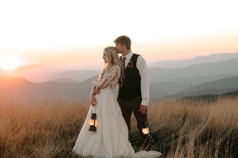 Bride & Groom holding lanterns at Sunset in the Mountains